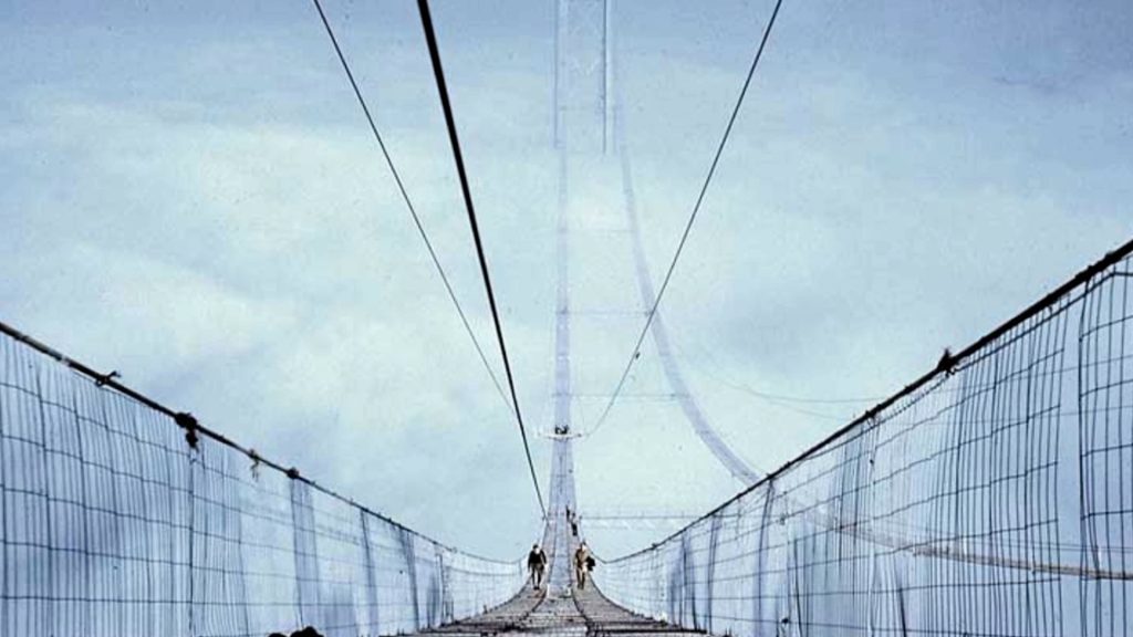 A photo of the Forth Road Bridge as it was being buit, focusing on the high wires above it. Illustrating a story about much needed improvements to Scottish transport.