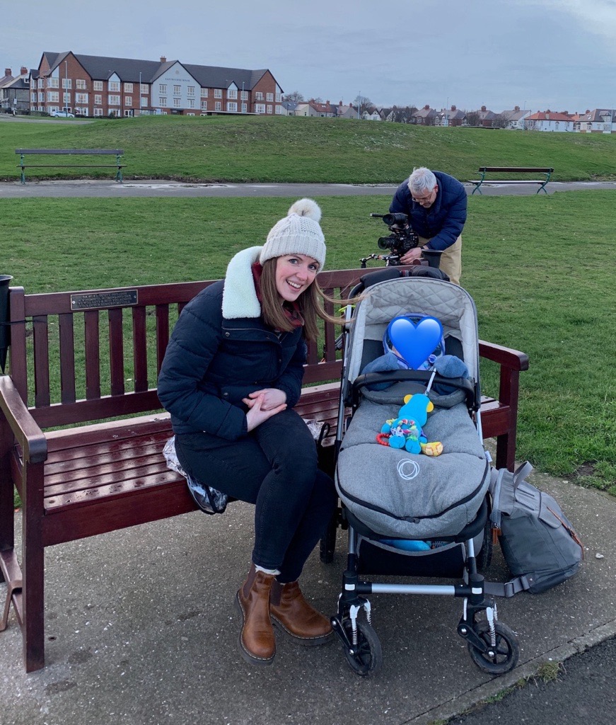 Sophie Ashcroft being filmed as part of Sunderland Til I Die with her young son in a buggy. next to her.