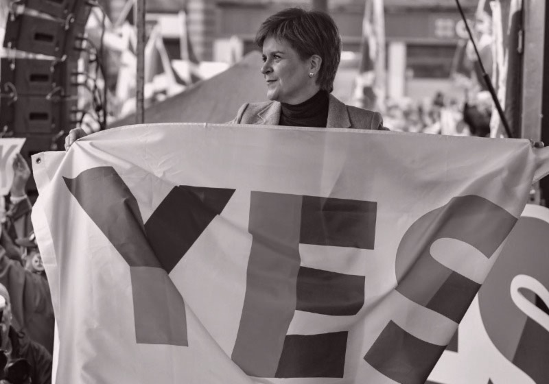 [ Nicola Sturgeon holding a 'yes' flag ]