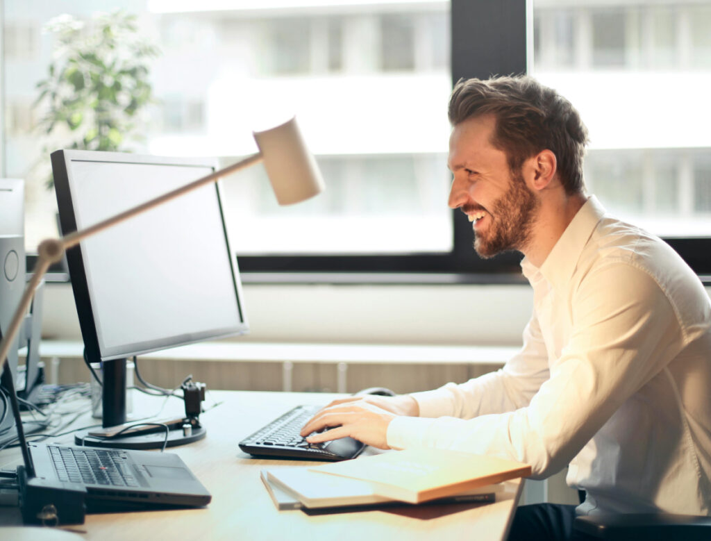 Stock image of a man sitting at a desk typing on a computer.