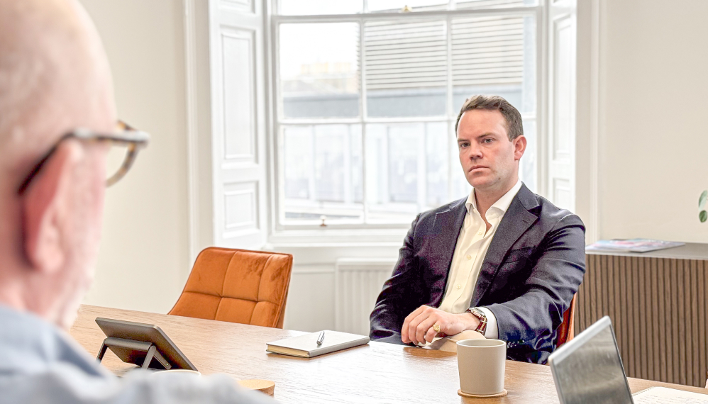 Two 56 Degrees North employees sit at a boardroom table.