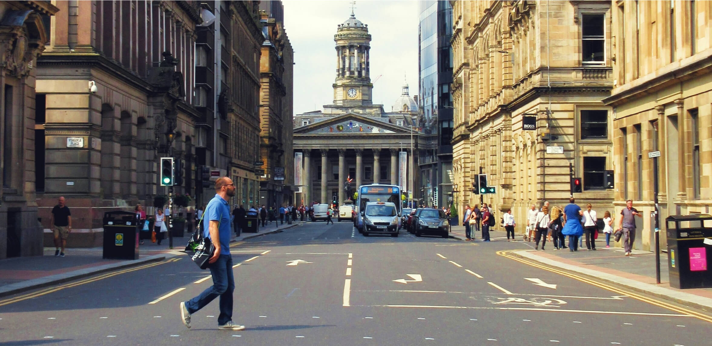 A man walks across a glasgow street.