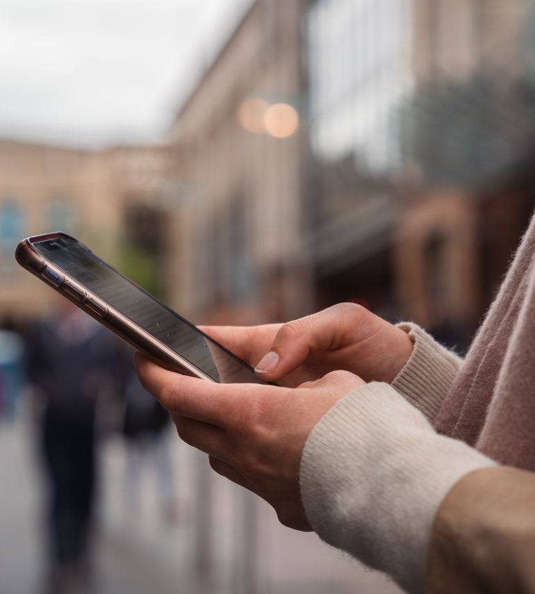 Close up image of a girl scrolling on her phone in Glasgow.