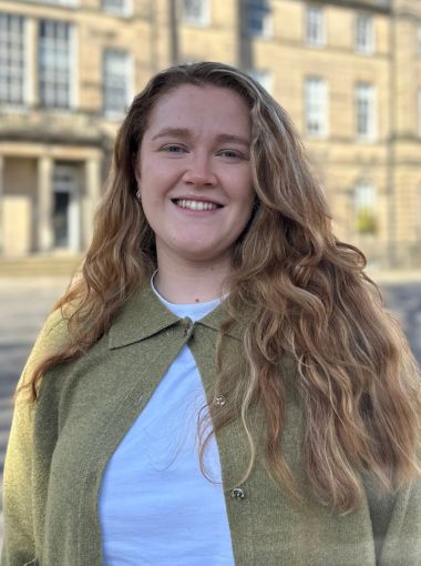 Louse Burt wearing a green cardigan standing in front of Charlotte Square.
