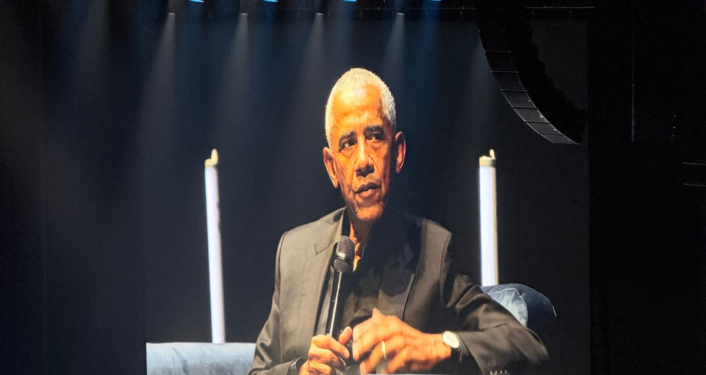 Obama in Glasgow on stage wearing a black suit.